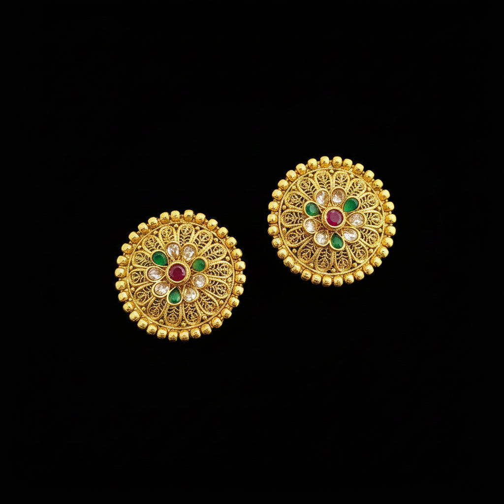 Pair of gold earrings with gemstones on a gray background