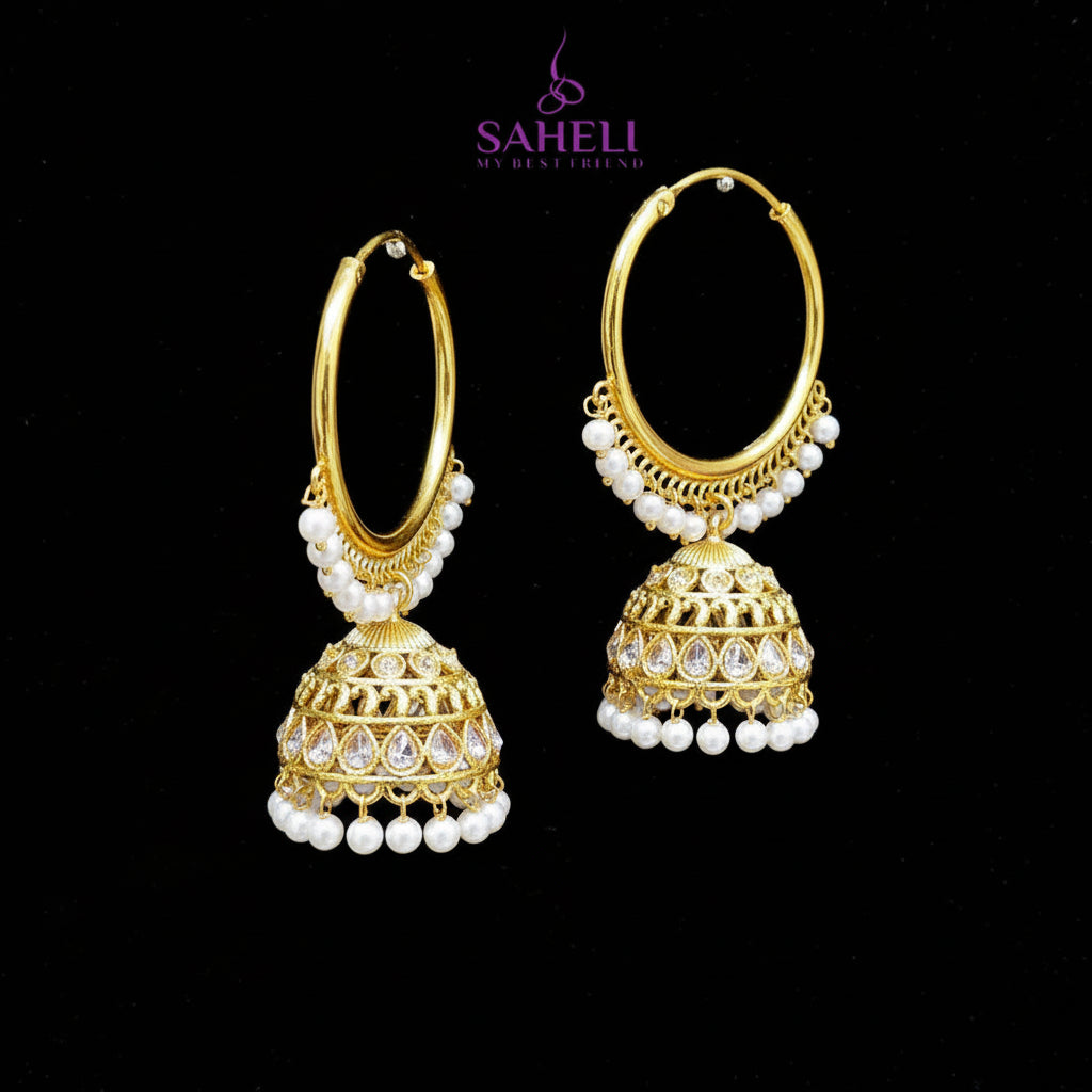 Gold hoop earrings with jhumka designs on a black background, featuring the brand 'Saheli'.