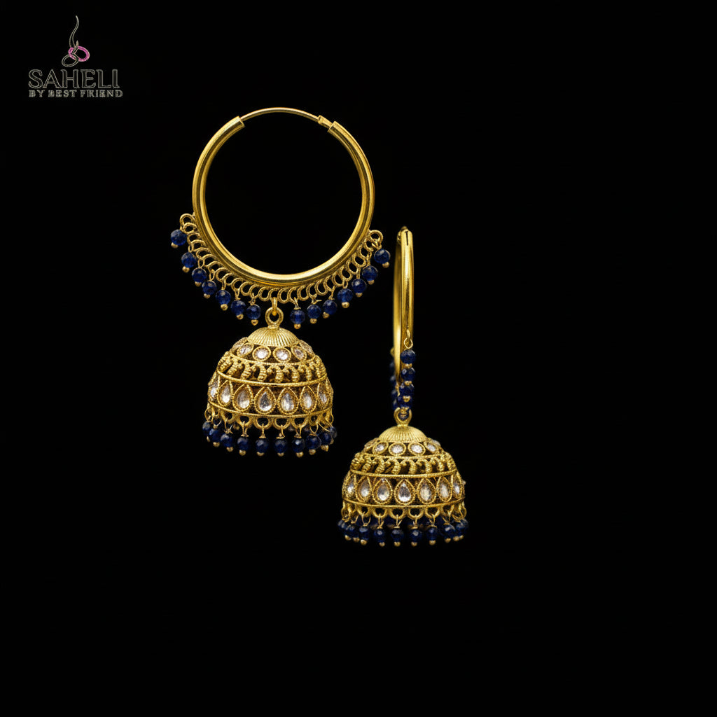 Gold hoop earrings with blue beads on a black stand against a gray background