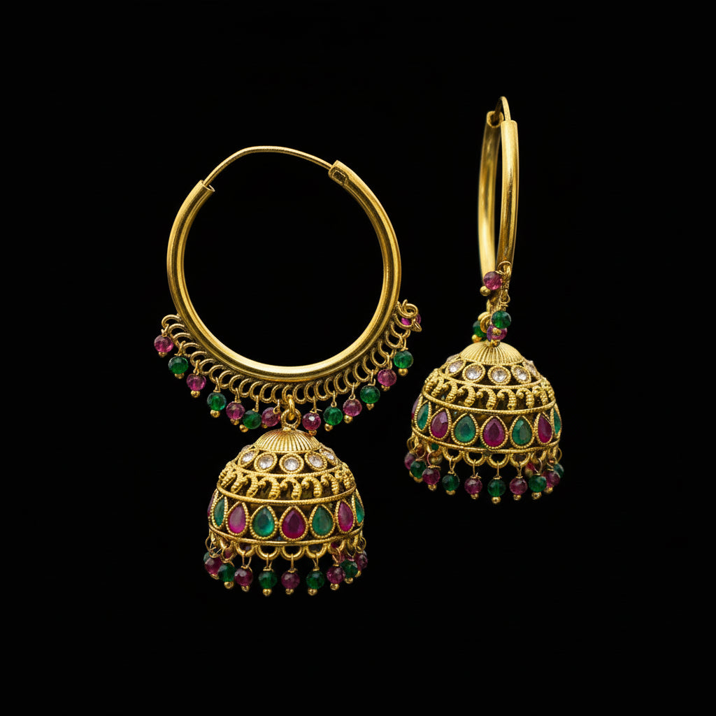Gold earrings with colorful gemstones on a black stand against a gray background