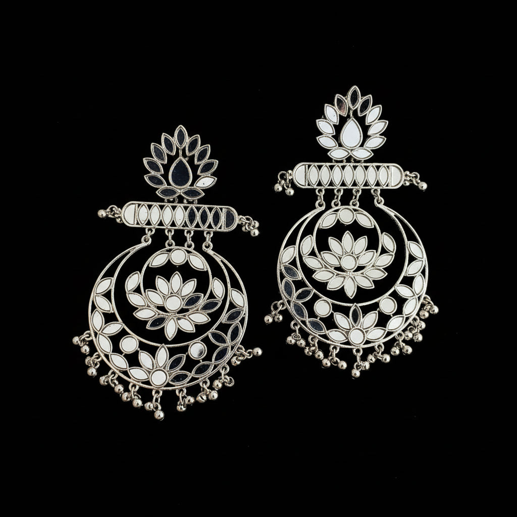 Pair of silver earrings with floral designs on a black background
