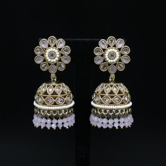 Pair of gold and crystal jhumka earrings on a black background