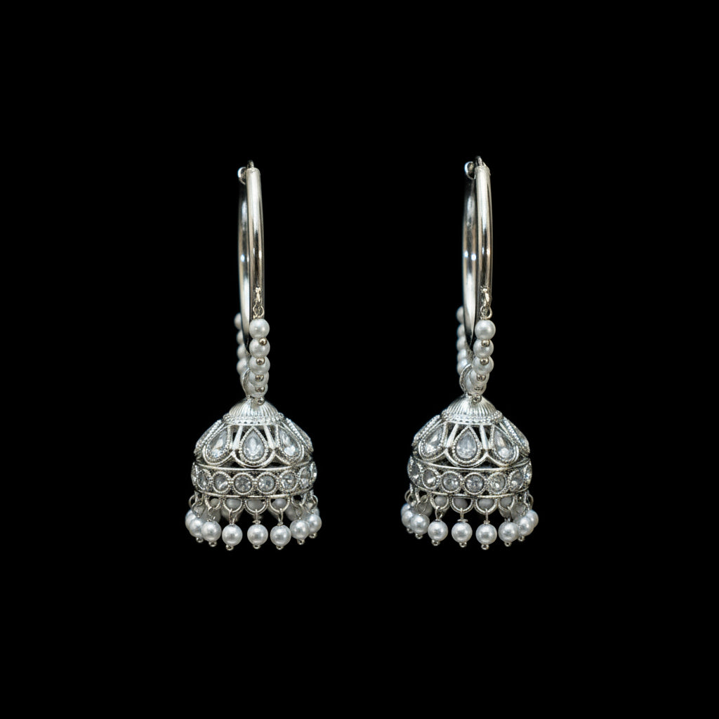 Silver earrings with pearl-like beads on a dark background