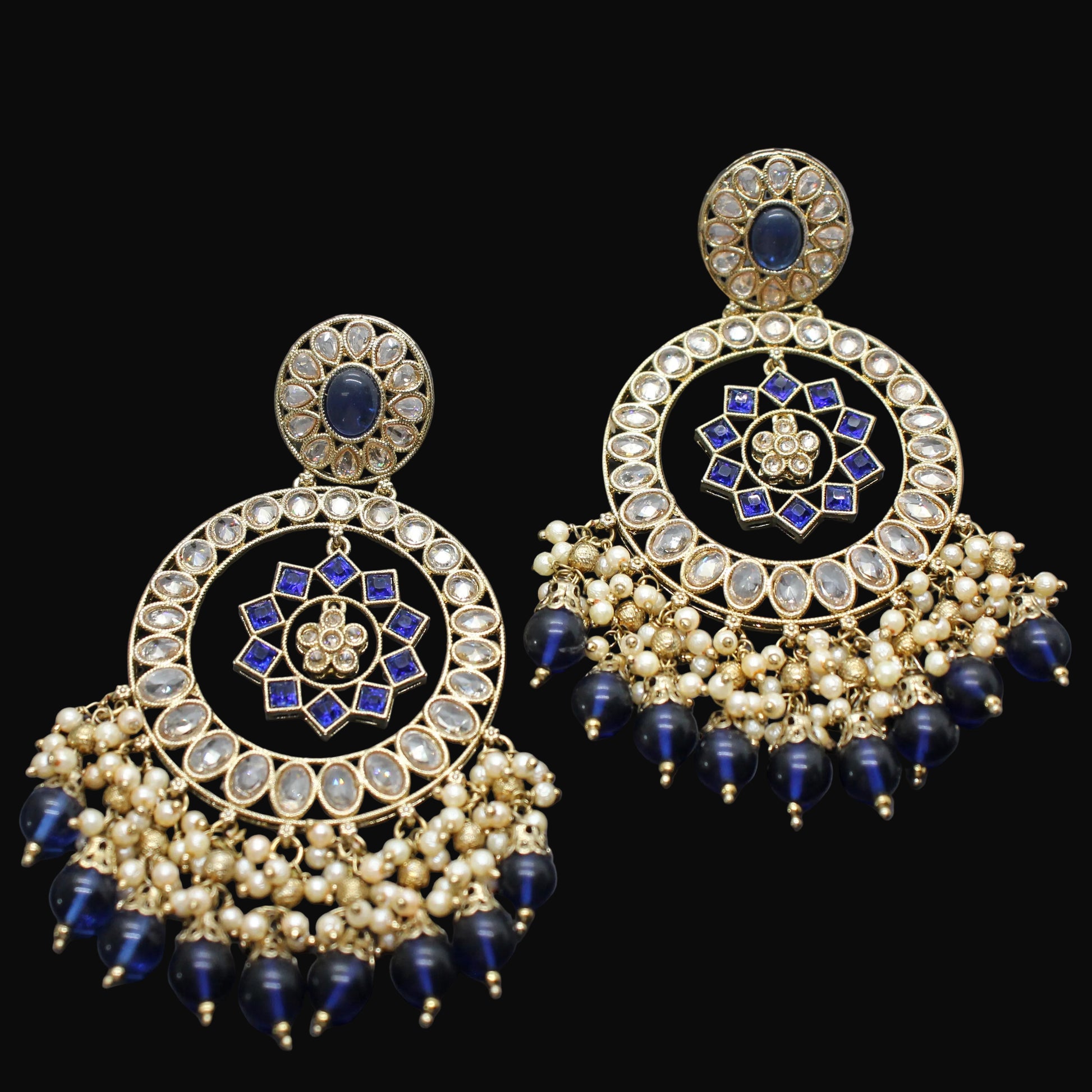 Pair of gold and blue earrings on a dark gray background