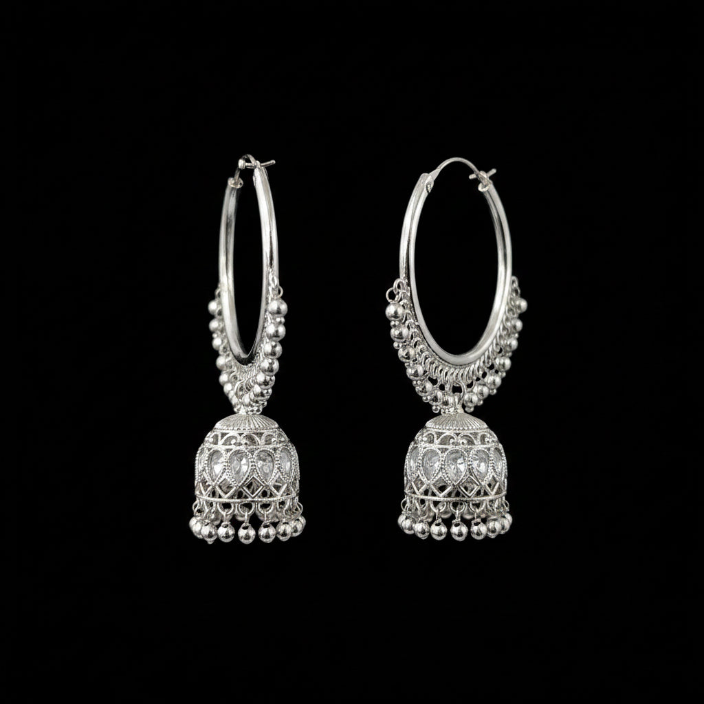 Silver hoop earrings with dangling jhumkas on a gray background, branded 'SAHELL'.