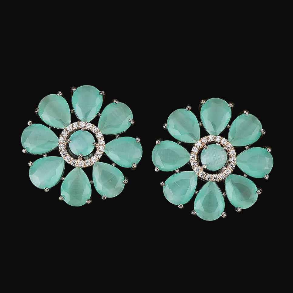 Pair of turquoise floral earrings on a wooden surface