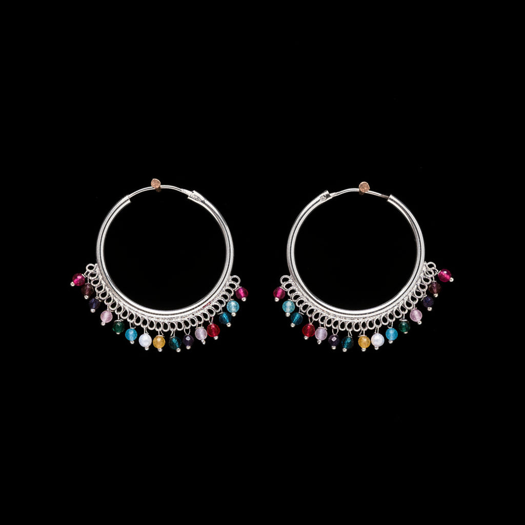 Pair of silver hoop earrings with colorful beads on a brown background