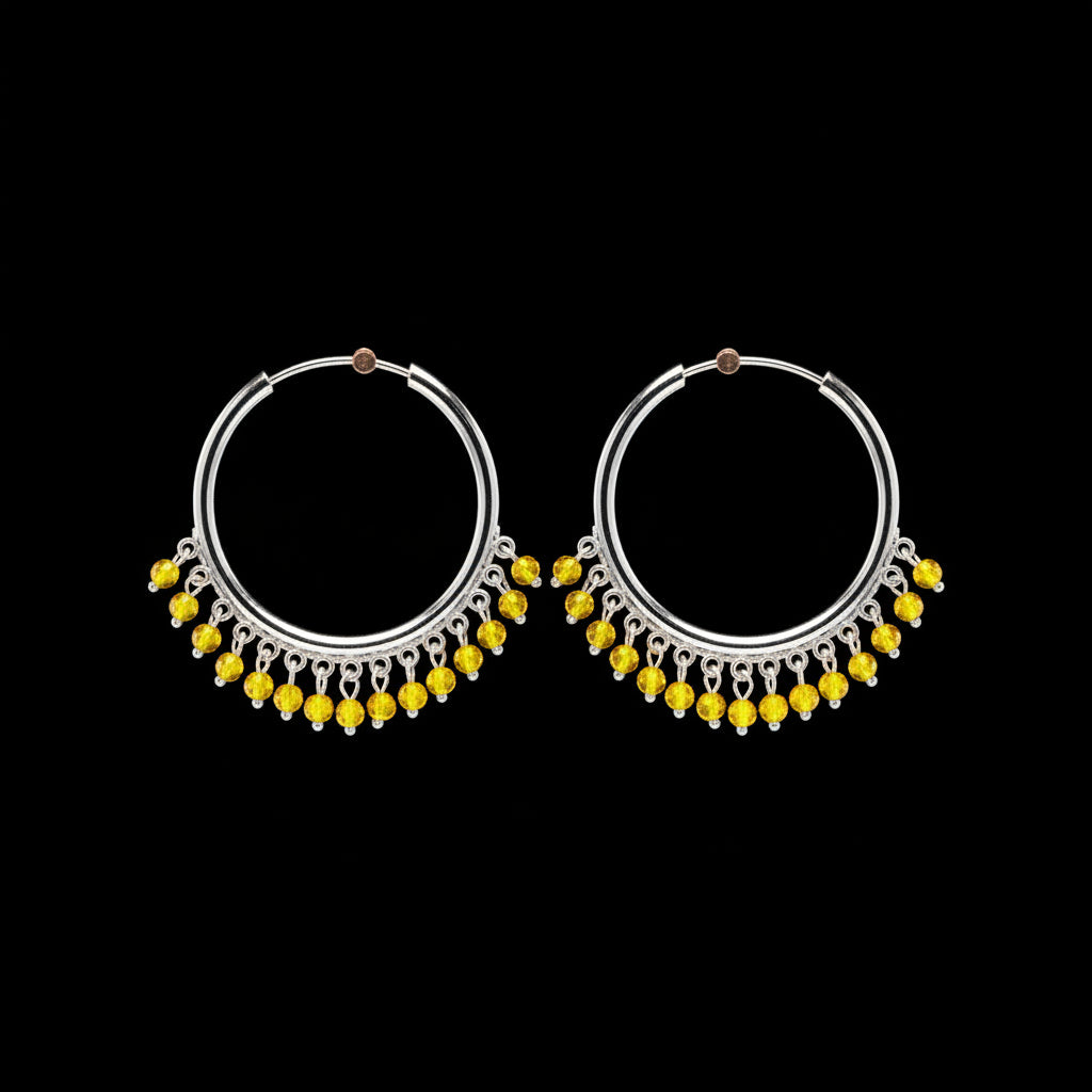 A pair of silver-tone hoop earrings with dangling beaded fringe, displayed on a textured orange-brown background.