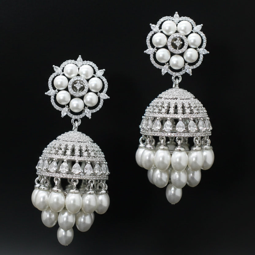 Pair of silver and pearl earrings on a black background