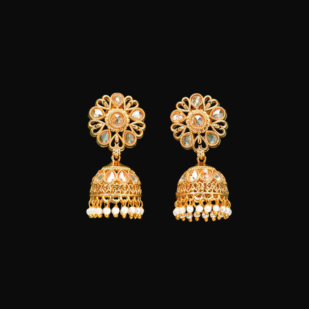 Gold earrings with floral top and bell-shaped bottom on a teal background