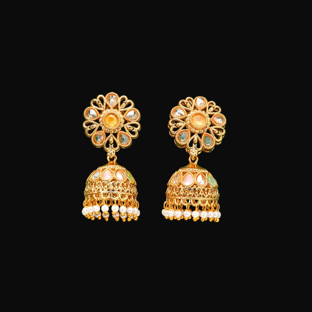 Gold floral earrings on a green background
