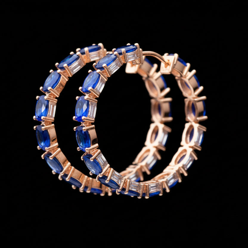 Pair of hoop earrings with blue gemstones on a black background