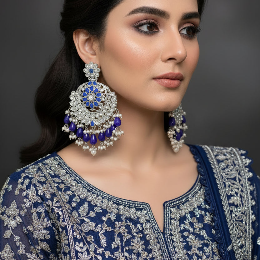 Pair of silver and blue earrings on a dark background