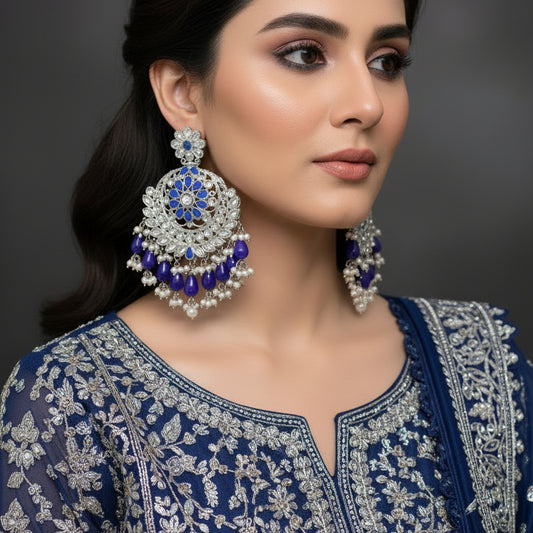Pair of silver and blue earrings on a dark background
