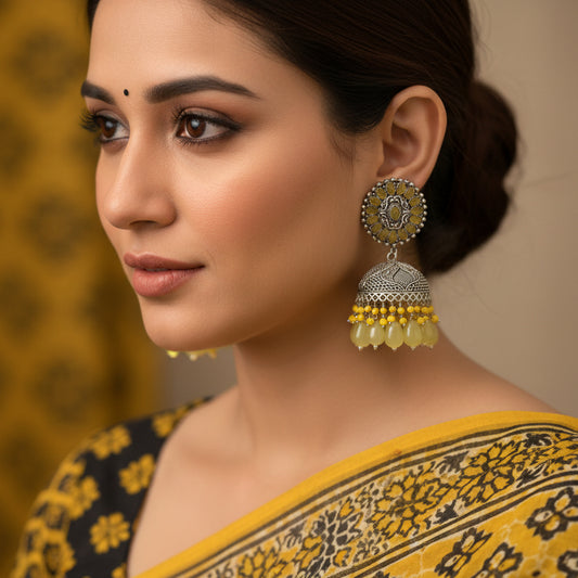 Pair of silver and yellow beaded earrings on a black background