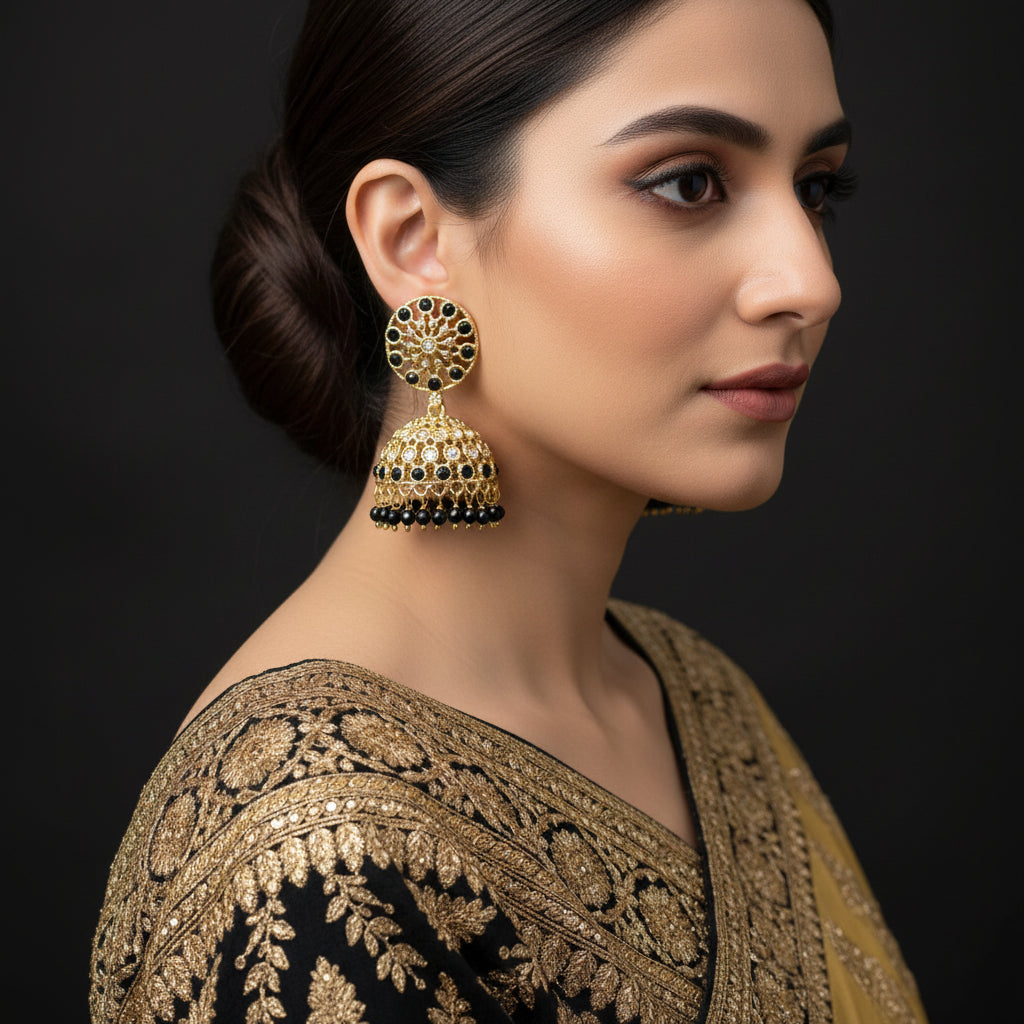 Gold and black earrings with 'Saheli' branding on a dark background