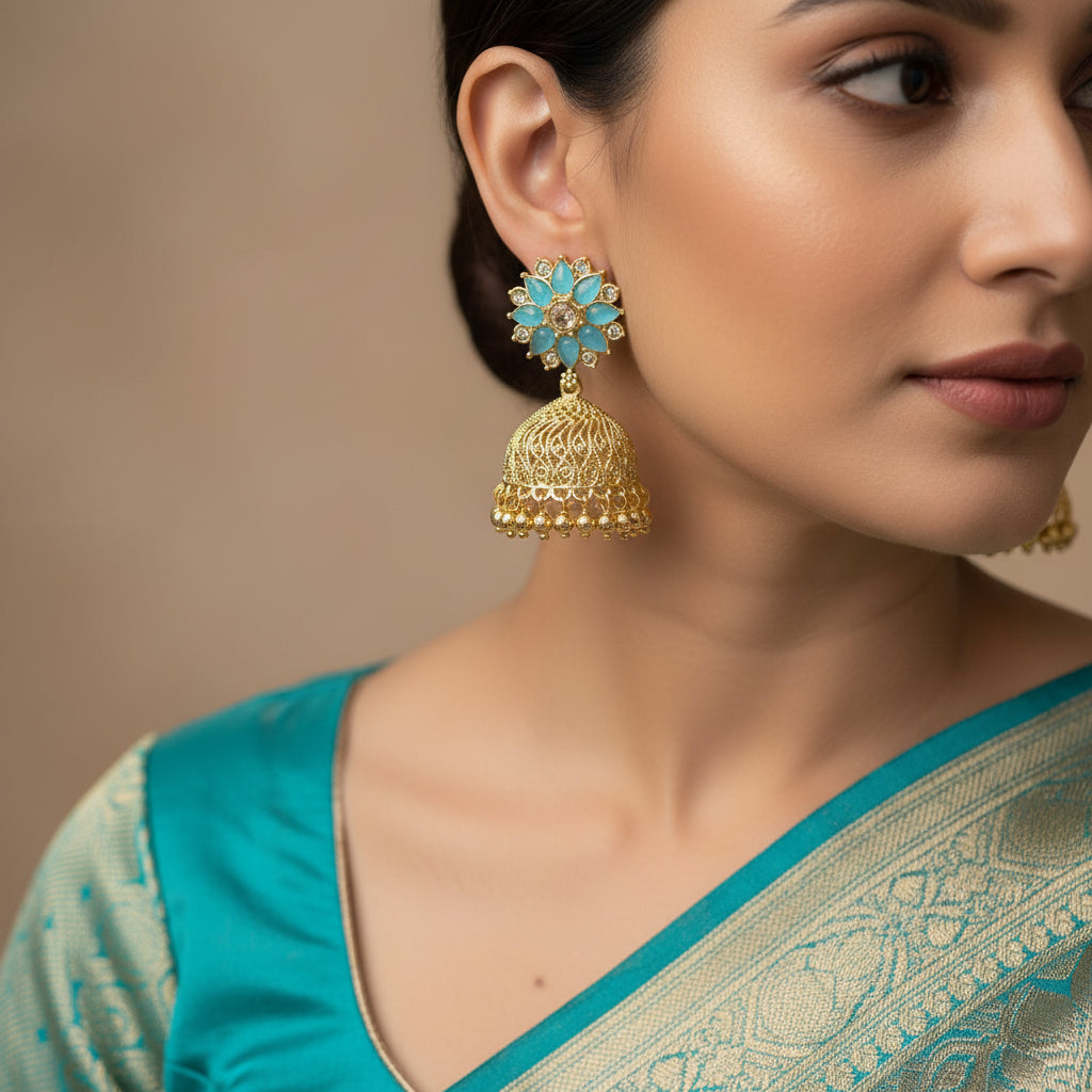 Gold and blue floral earrings with 'Saheli' branding on a black background