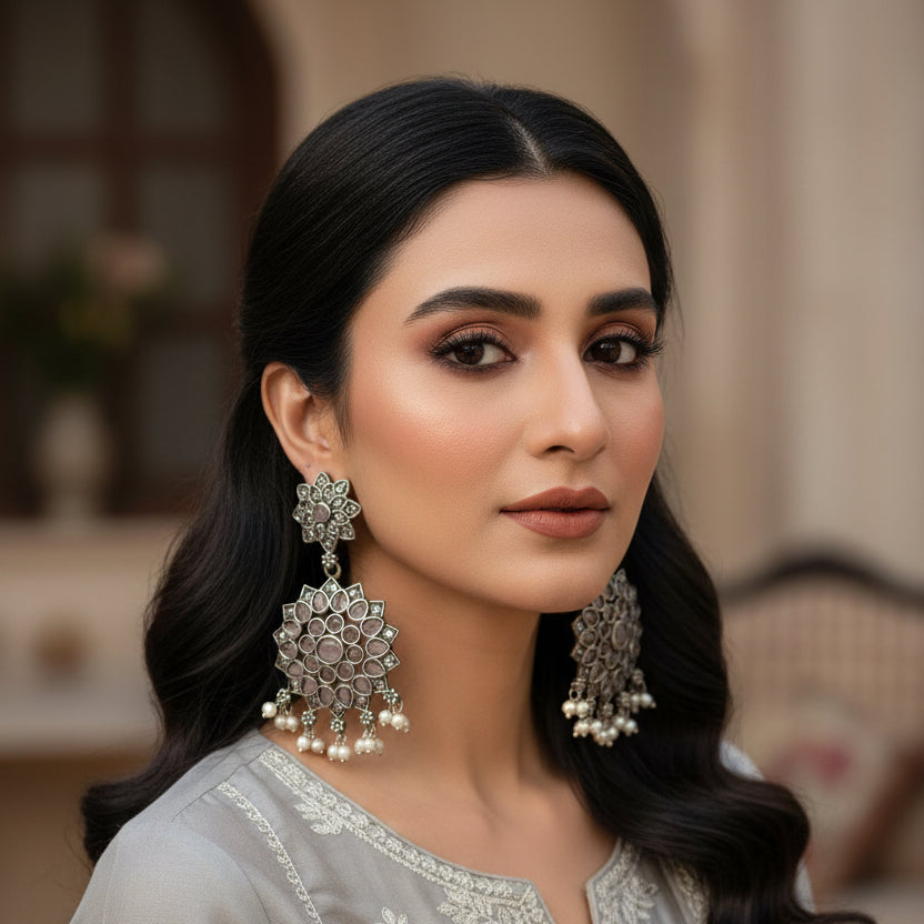 Pair of silver floral earrings on a black stand