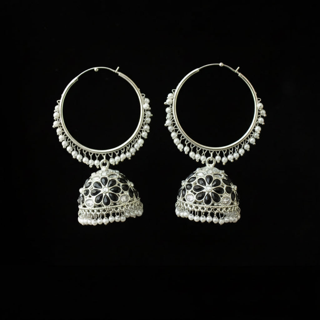Pair of silver hoop earrings with jhumka designs on a black background