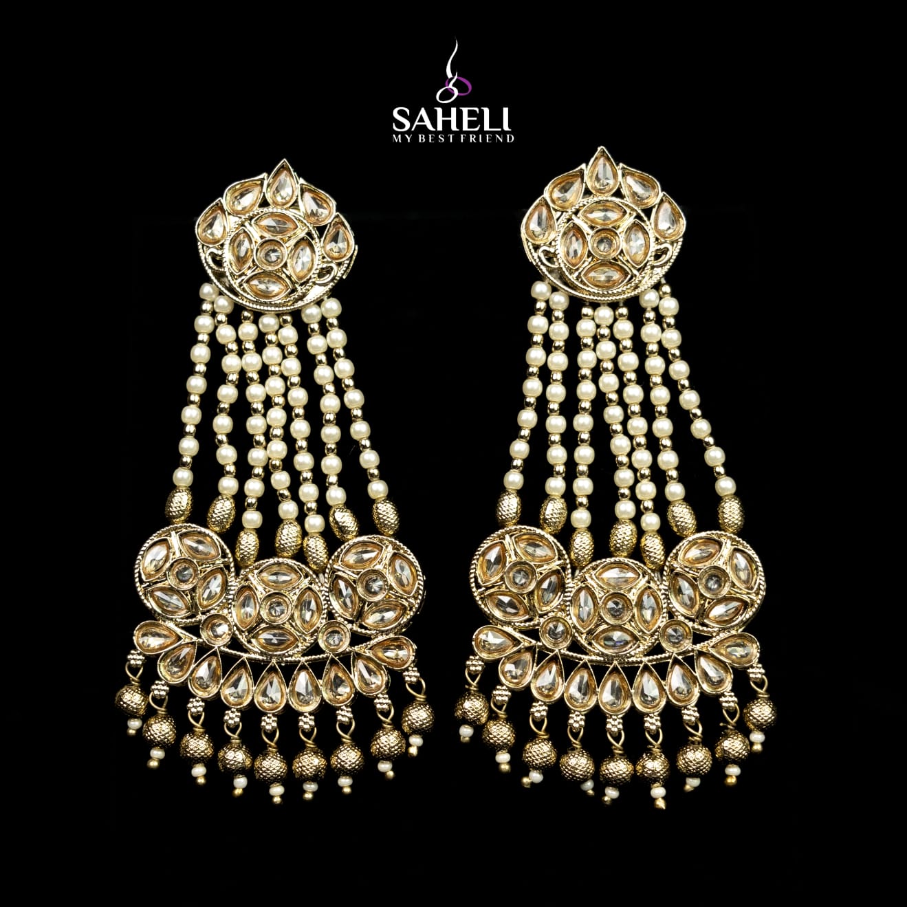 Ornate gold and pearl earrings with 'Saheli' branding on a black background