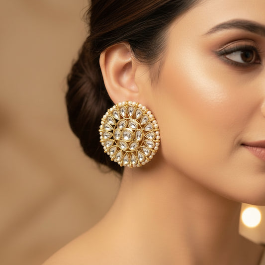 Pair of gold and pearl earrings on a black background