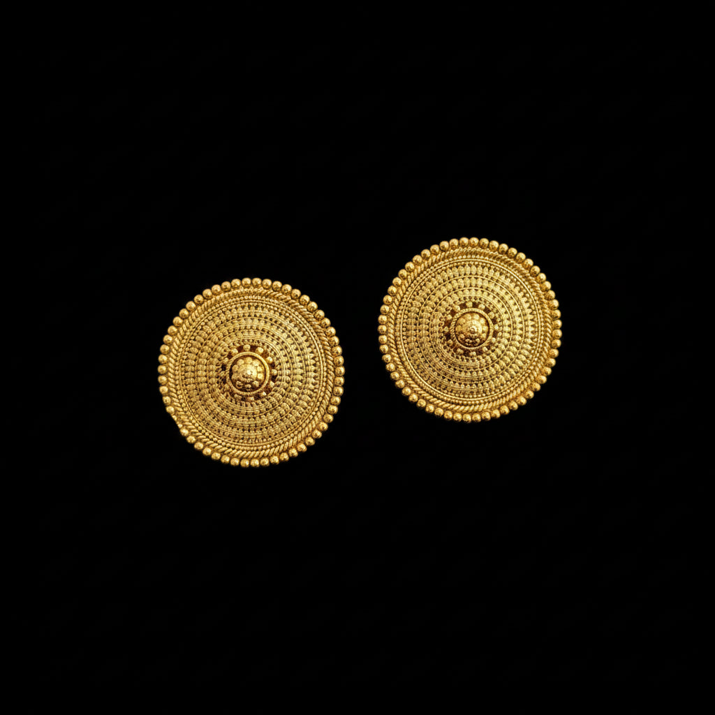 Pair of gold circular earrings on a dark gray background