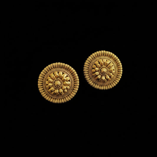 Pair of gold earrings on a dark gray background