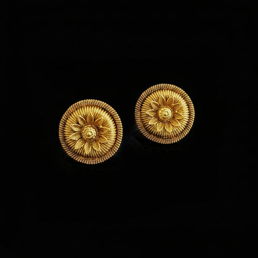 Pair of gold earrings on a dark gray background