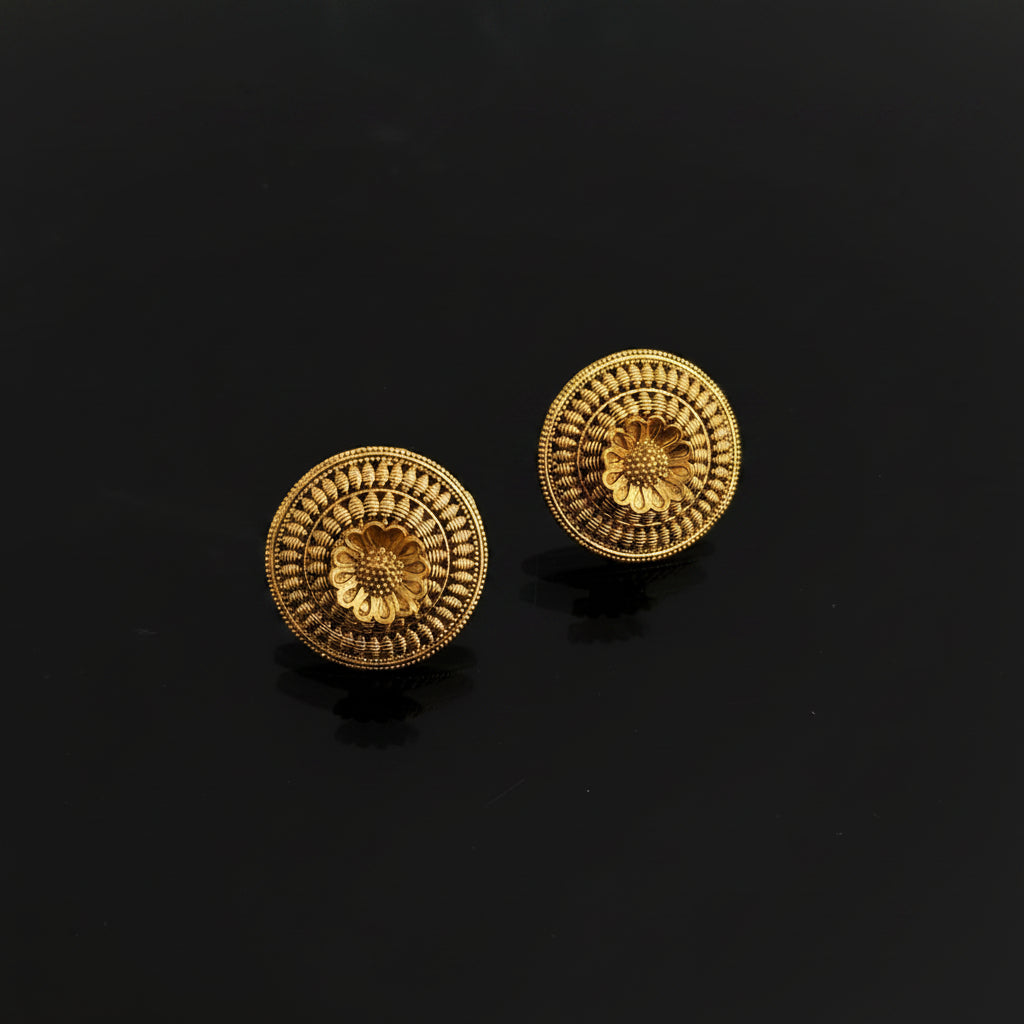 Pair of gold earrings on a dark gray background