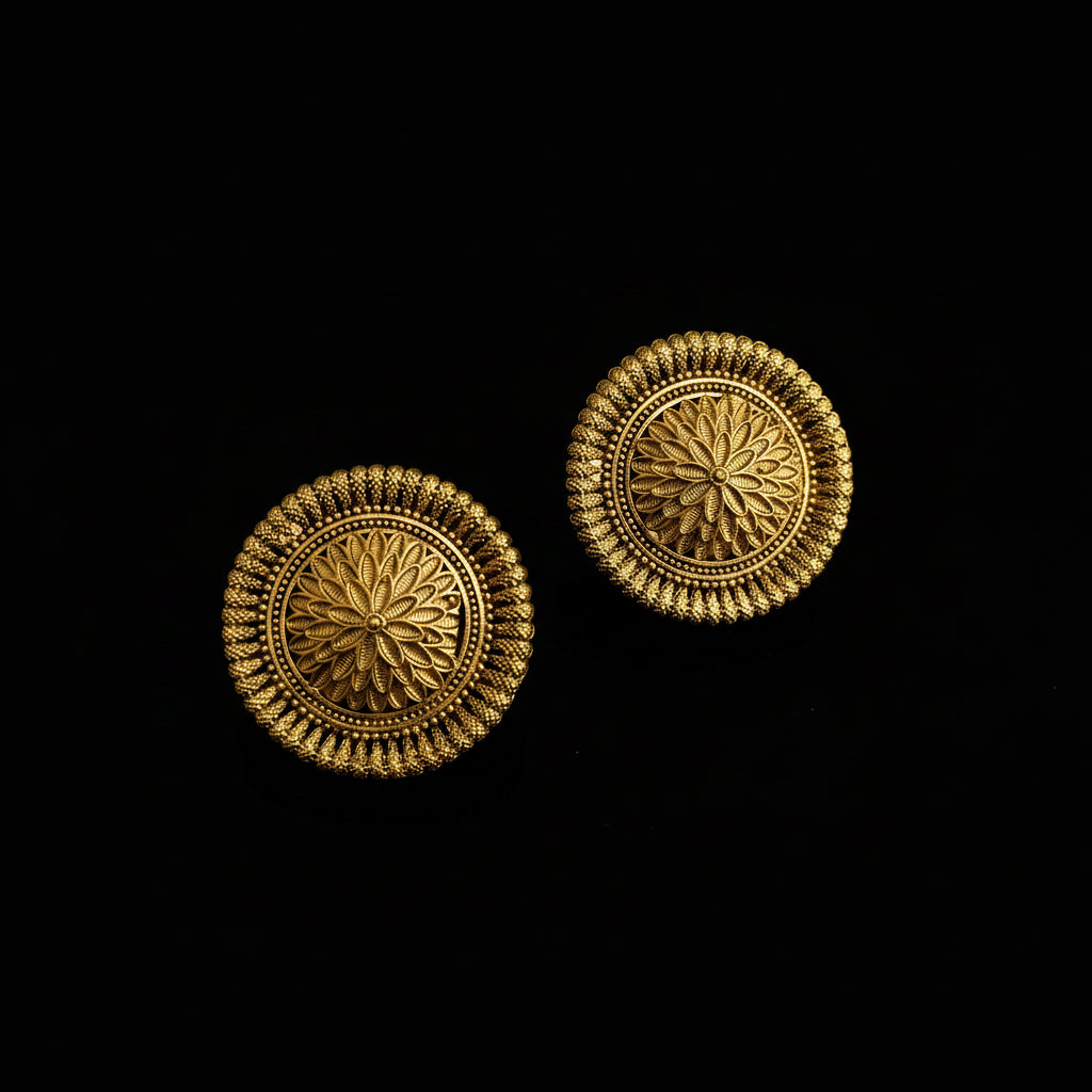 Gold earrings with intricate design on a dark background, featuring the brand 'Saheli'.