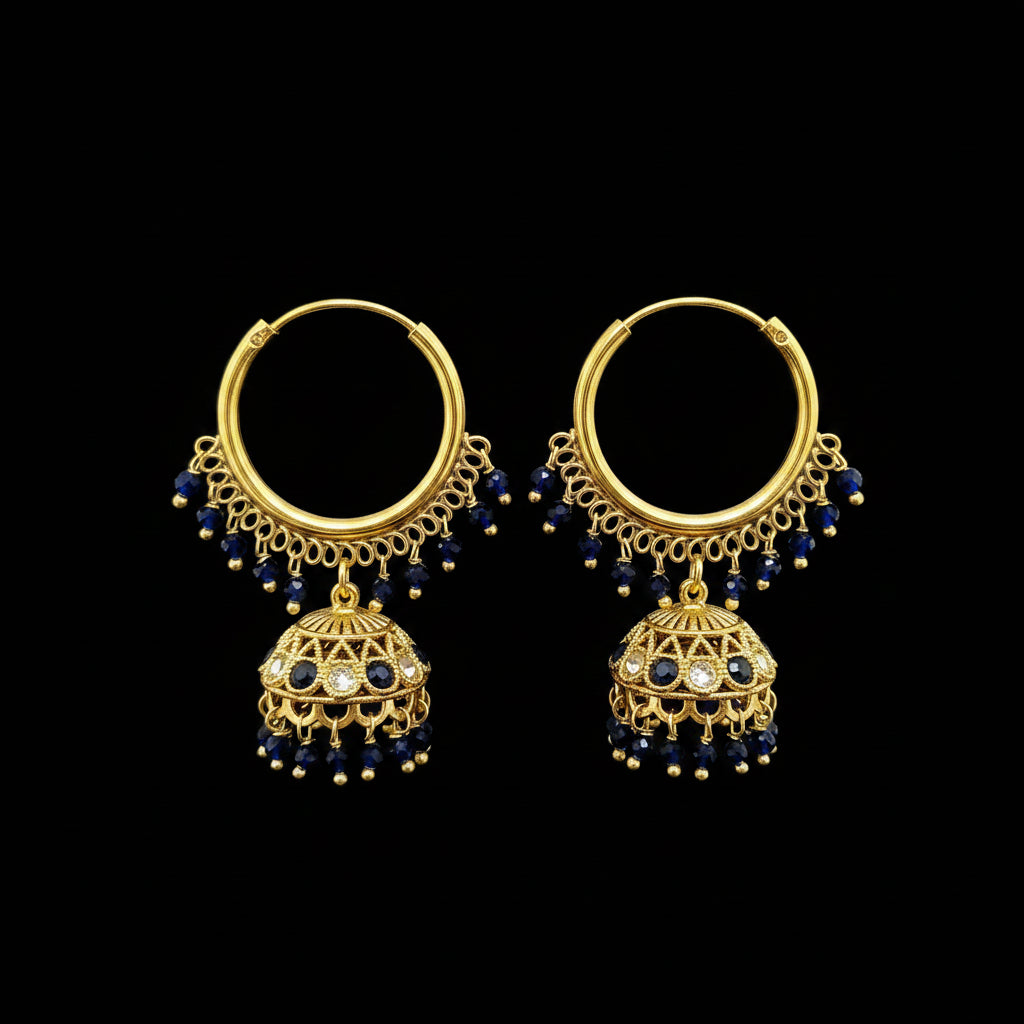 A pair of gold-toned hoop earrings with dangling filigree jhumka-style bells, dark blue bead drops, and small clear stones, displayed on a gray jewelry stand against a light gray background.