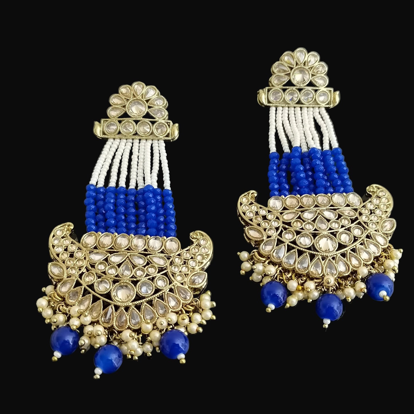 Pair of decorative earrings with blue and white beads on a dark background