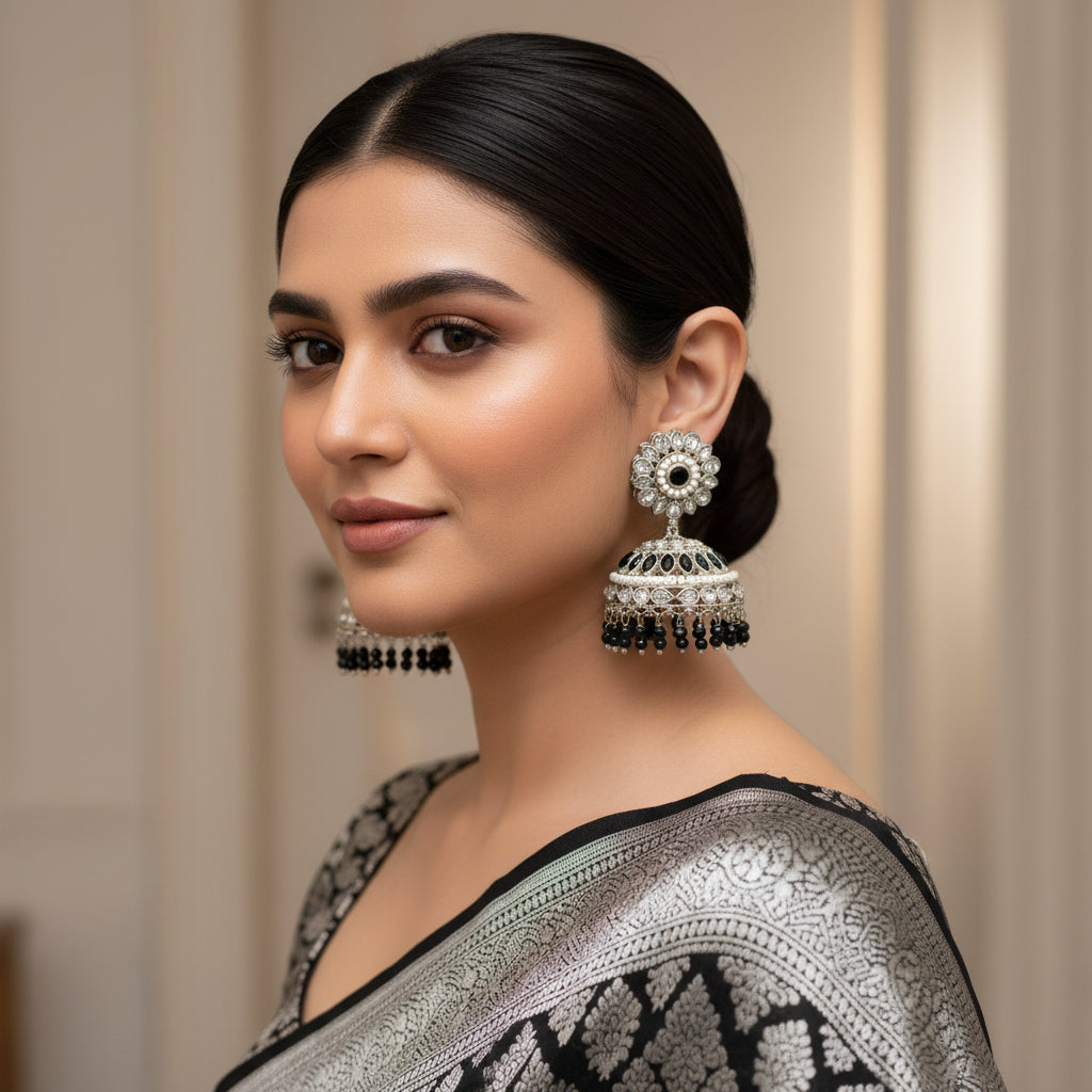 Pair of silver and black earrings on a dark background