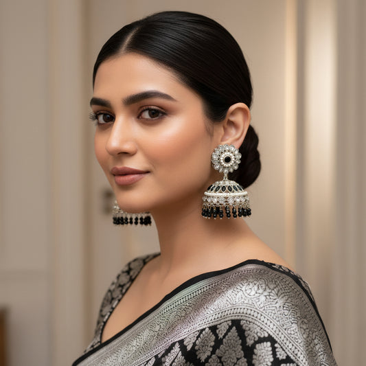 Pair of silver and black earrings on a dark background