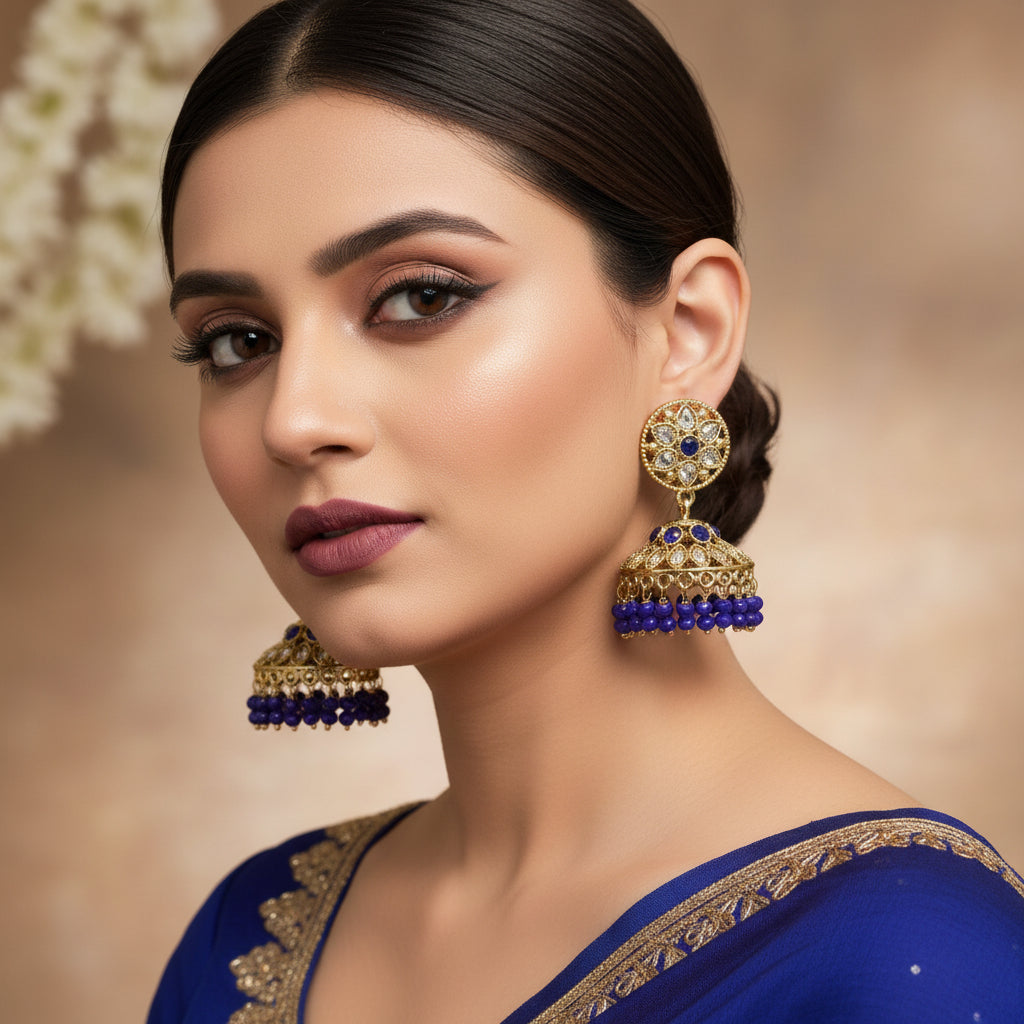 Pair of gold and blue beaded earrings on a gray background