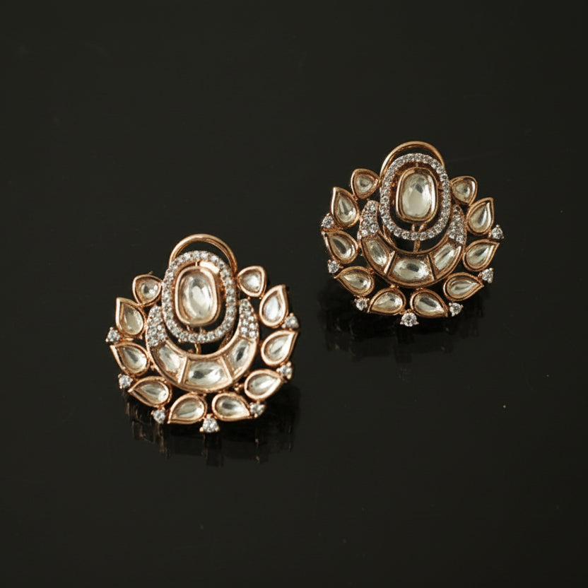 Pair of gold earrings with gemstones on a black background