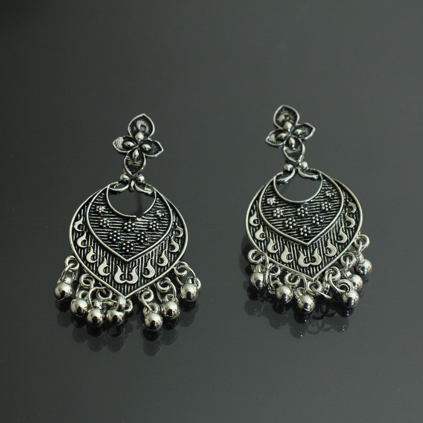 Pair of silver earrings on a black background