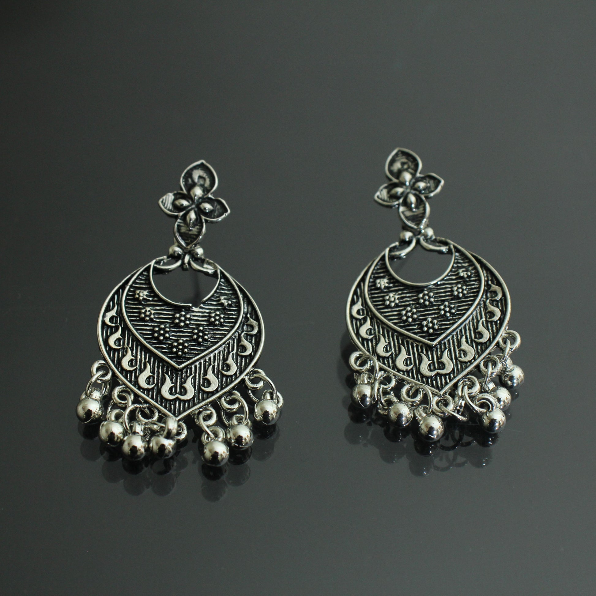 Pair of silver earrings on a black background