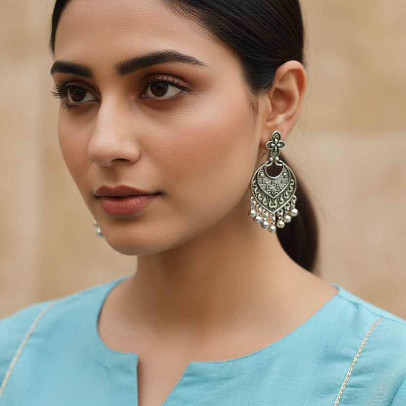 Pair of silver earrings on a black background