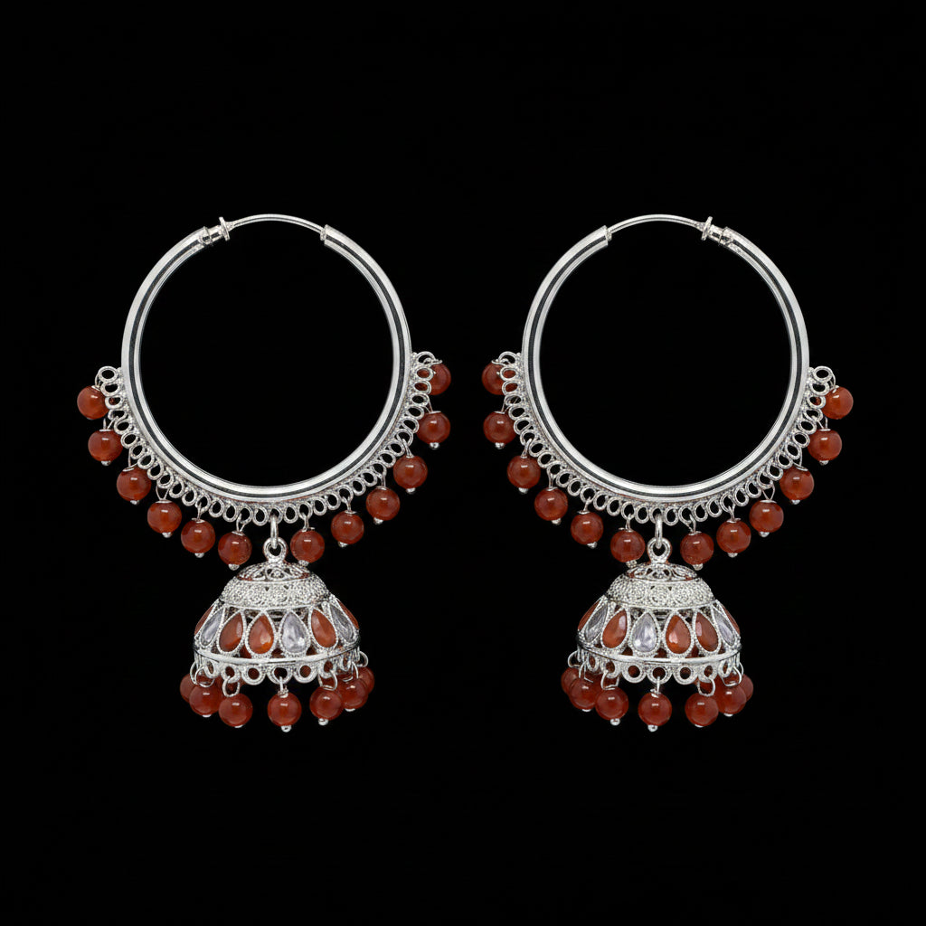 Pair of silver hoop earrings with red beads on a black background