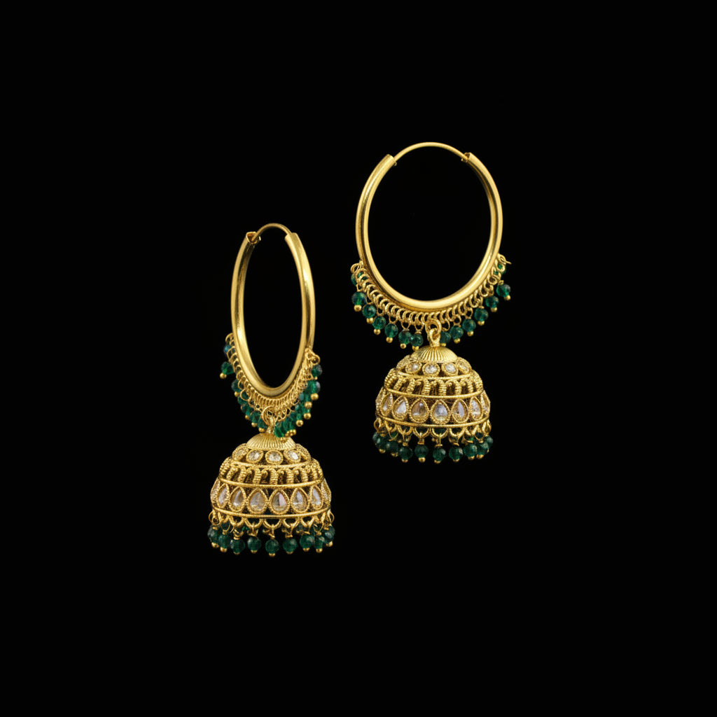 Gold hoop earrings with green gemstones on a black background
