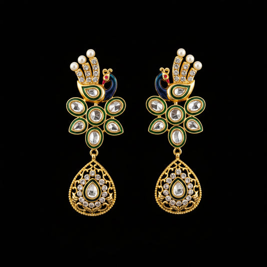 A pair of gold-plated Indian Kundan earrings with green enamel, white faux pearls, and clear crystals, displayed on a black Y-shaped stand against a gray background with the brand logo 'SAHeli My Best Friend' in the center.