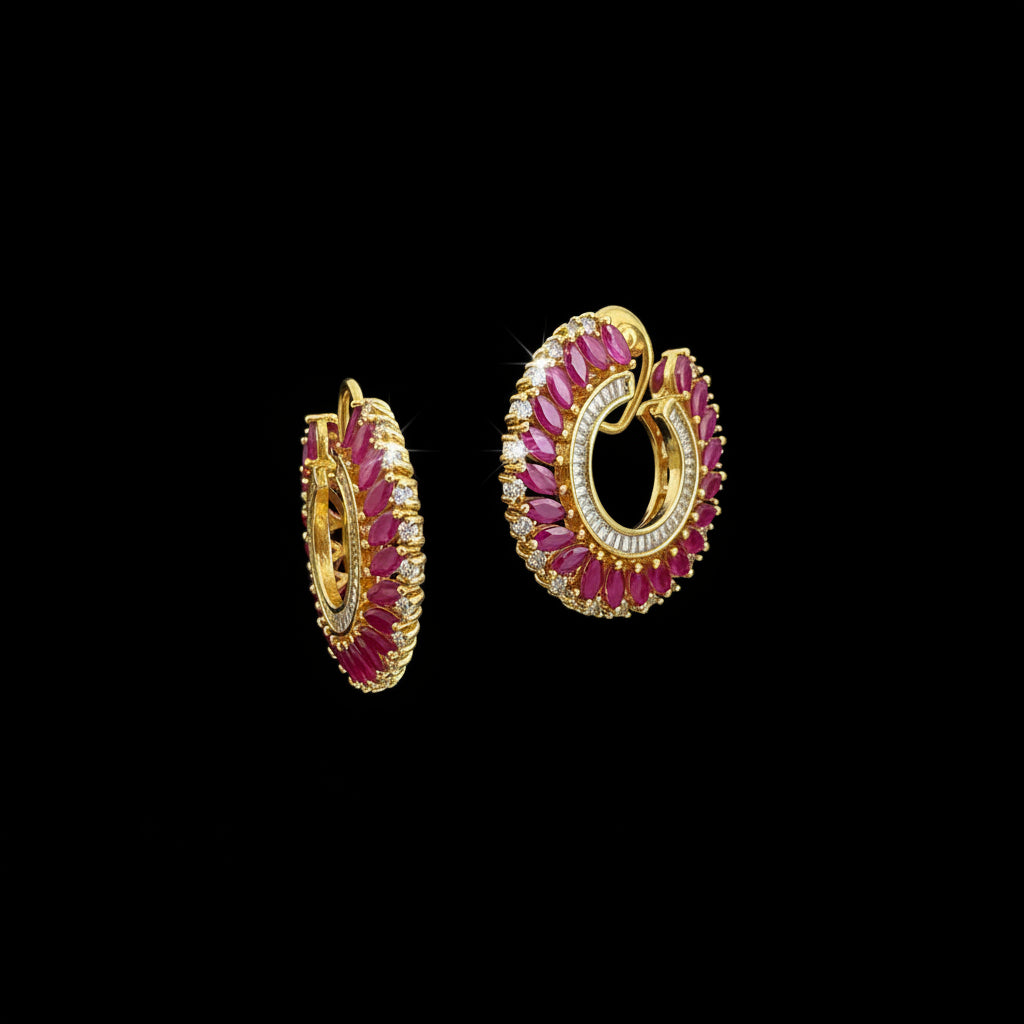 A pair of gold crescent-shaped hoop earrings decorated with bright pink marquise-cut stones and rows of small clear stones, displayed on a dark reflective surface with the SAHELI MY BEST FRIEND logo above.