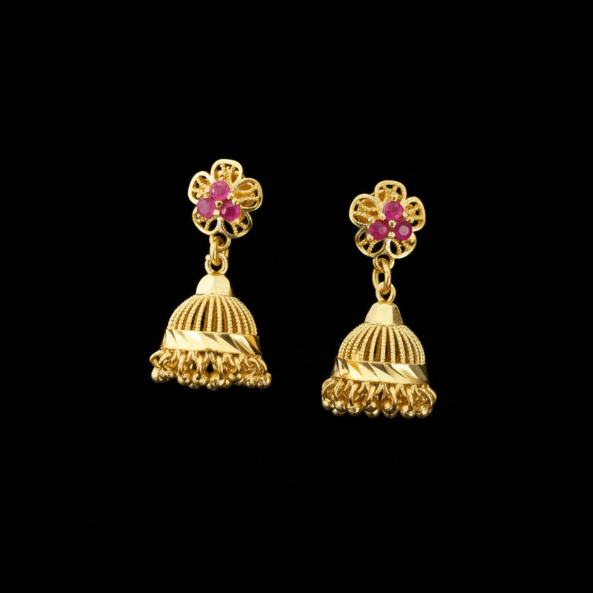 Gold earrings with pink gemstones on a black stand against a gray background