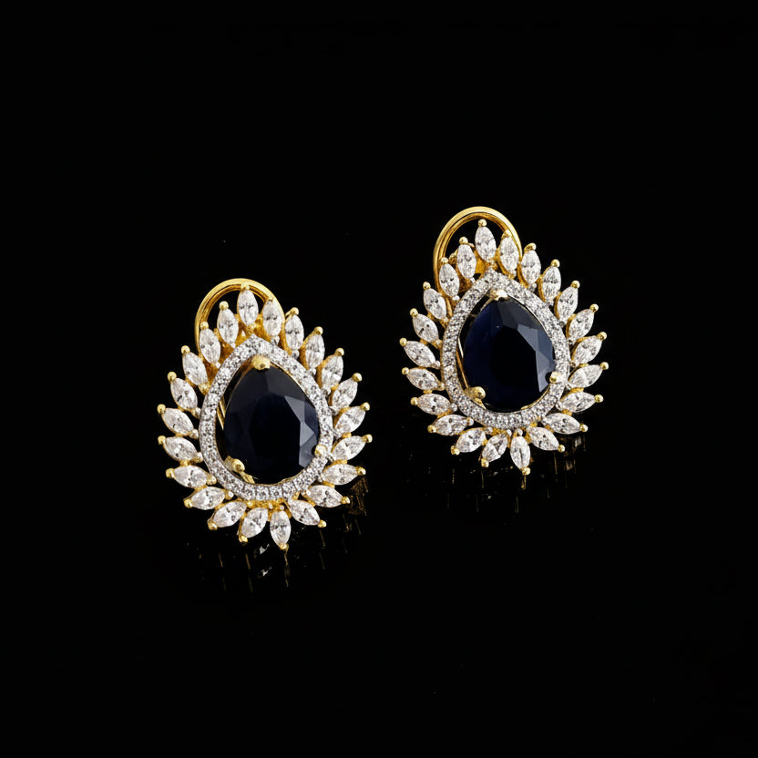 Gold and black earrings on a gray background with 'Sahelli' branding.