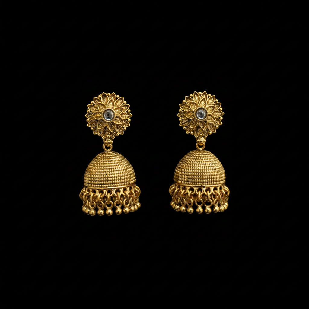 Gold jhumka earrings on a black stand with a gray background