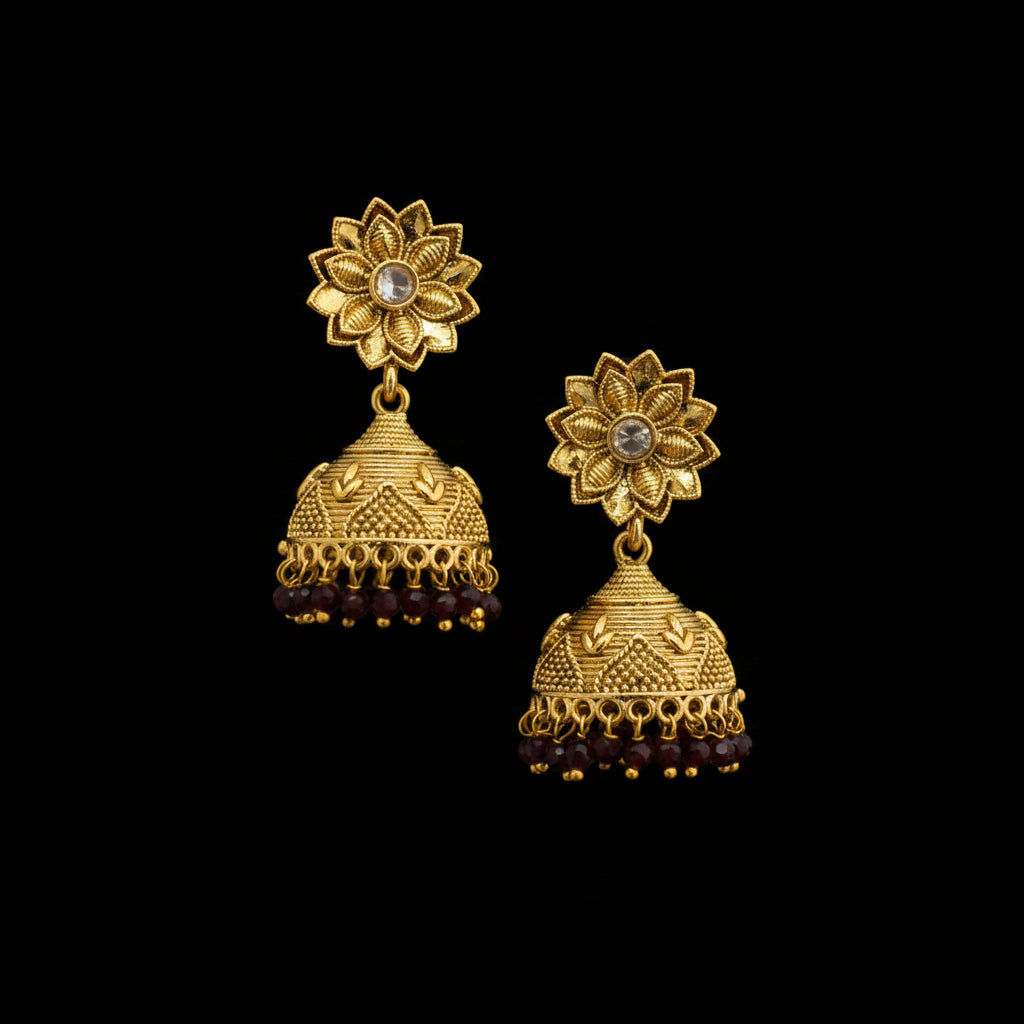 Gold floral earrings on a black stand with a gray background