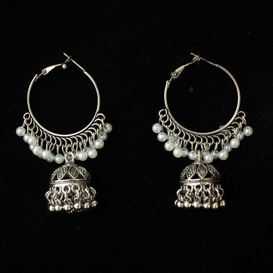 Pair of silver hoop earrings with pearl-like beads on a black background