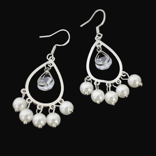 Pearl and crystal drop earrings on a dark background