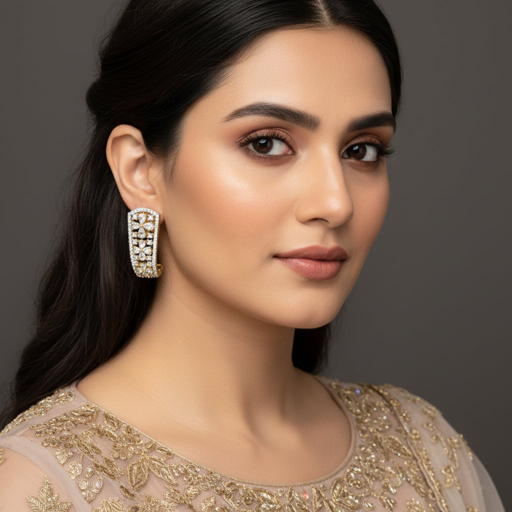 Pair of diamond earrings on a dark background with 'Saheli' branding.